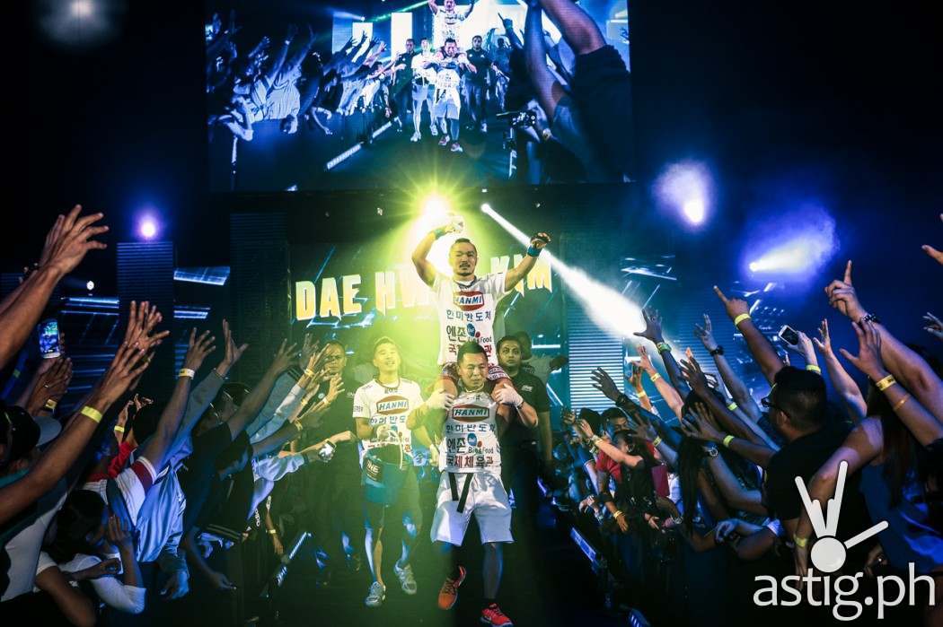 Dae Hwan Kim from South Korea enters the ring while being carried on the back by his team mates