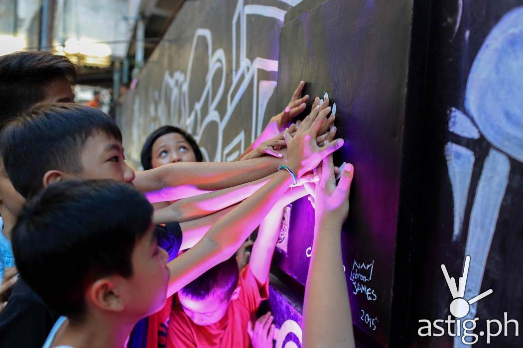Youth residents of Tenement Court putting their hands to LBJ's handprint