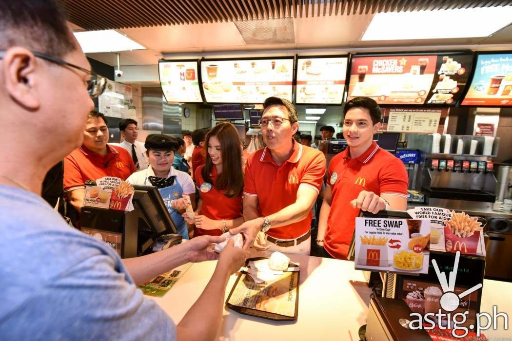 McDonald’s President and Chief Executive Officer Kenneth S. Yang (center) distributed free McMuffin sandwiches to customers. Together with him are McDonald’s endorsers Alden Richards and Maine Me