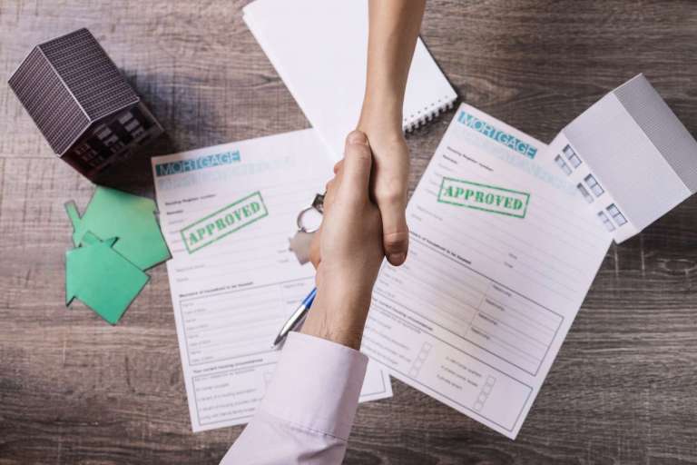 Realtor and client shaking hands in agreement (via Freepik)