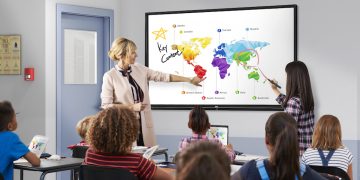 Teacher with tablet in front of elementary school class