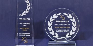 A pair of trophies on a table Description automatically generated